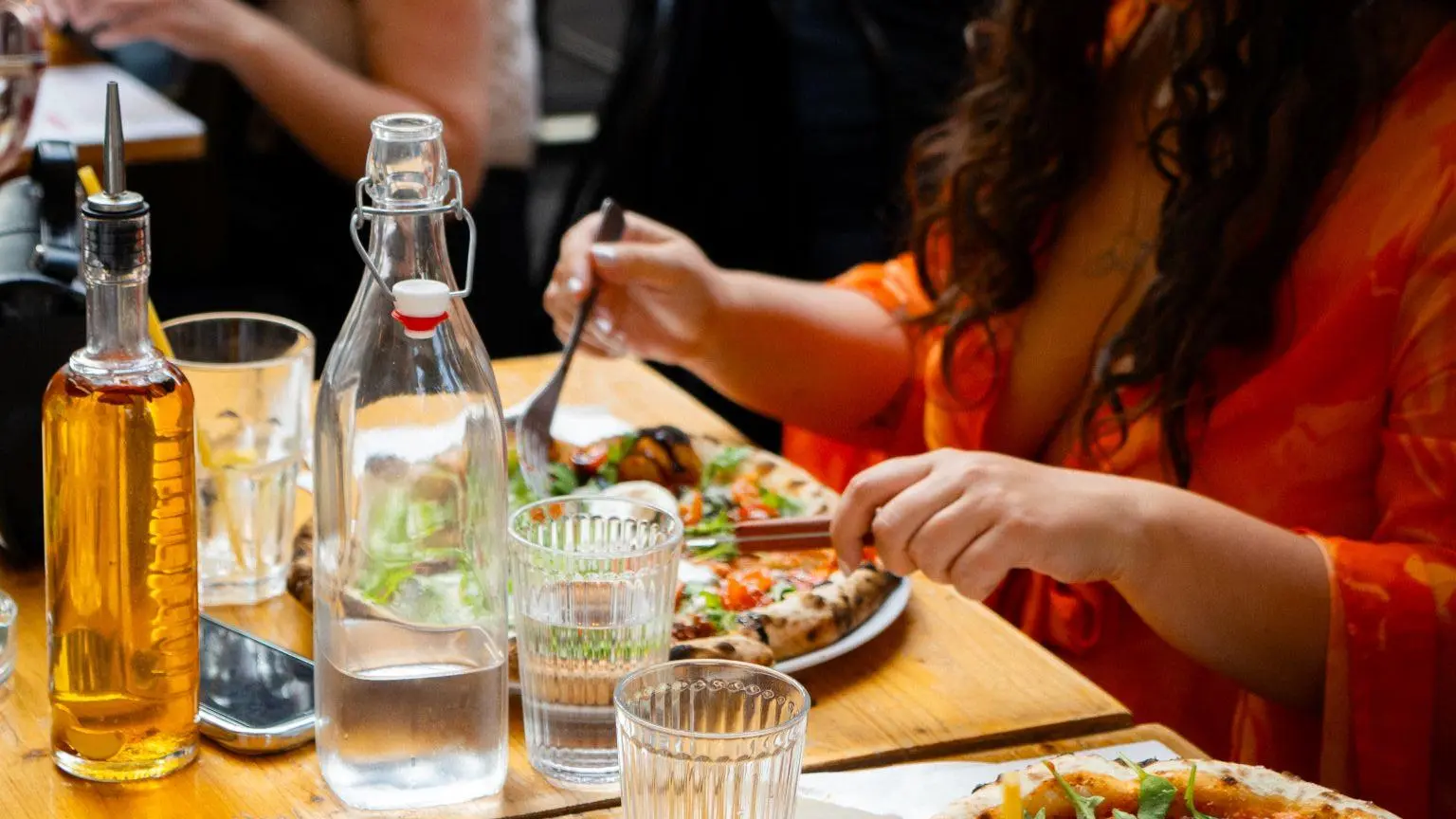 table avec une cliente et des pizzas