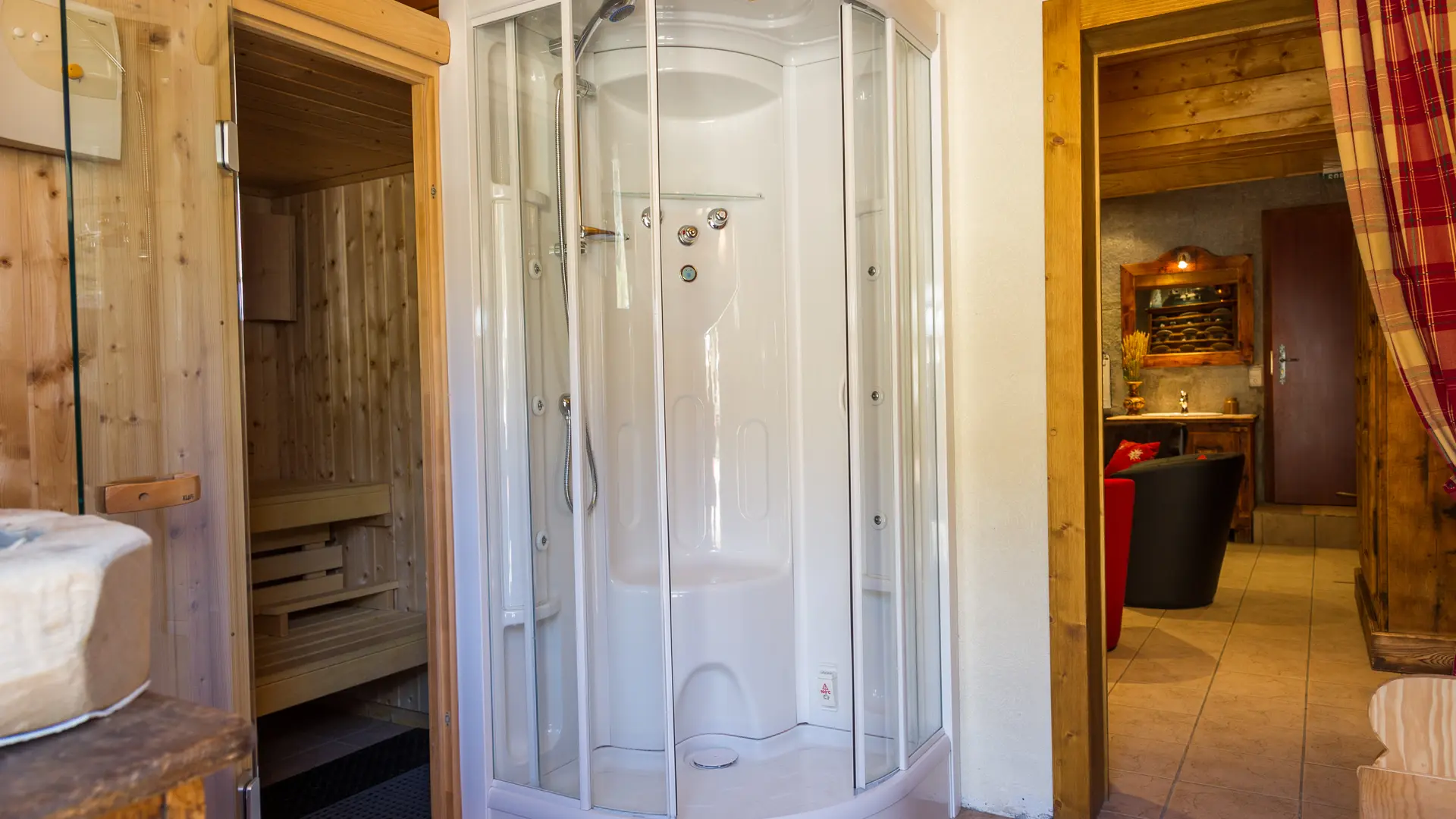 Sauna avec sa douche à côté de l'espace détente