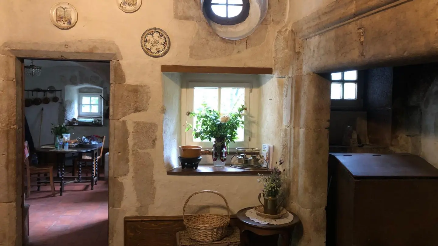 Ambiance minérale dans le salon du château avec sa cheminée monumentale.