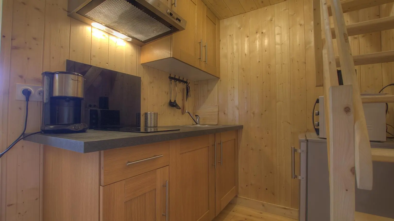 Espace Kitchenette avec un escalier qui donne accès à la mezzanine.