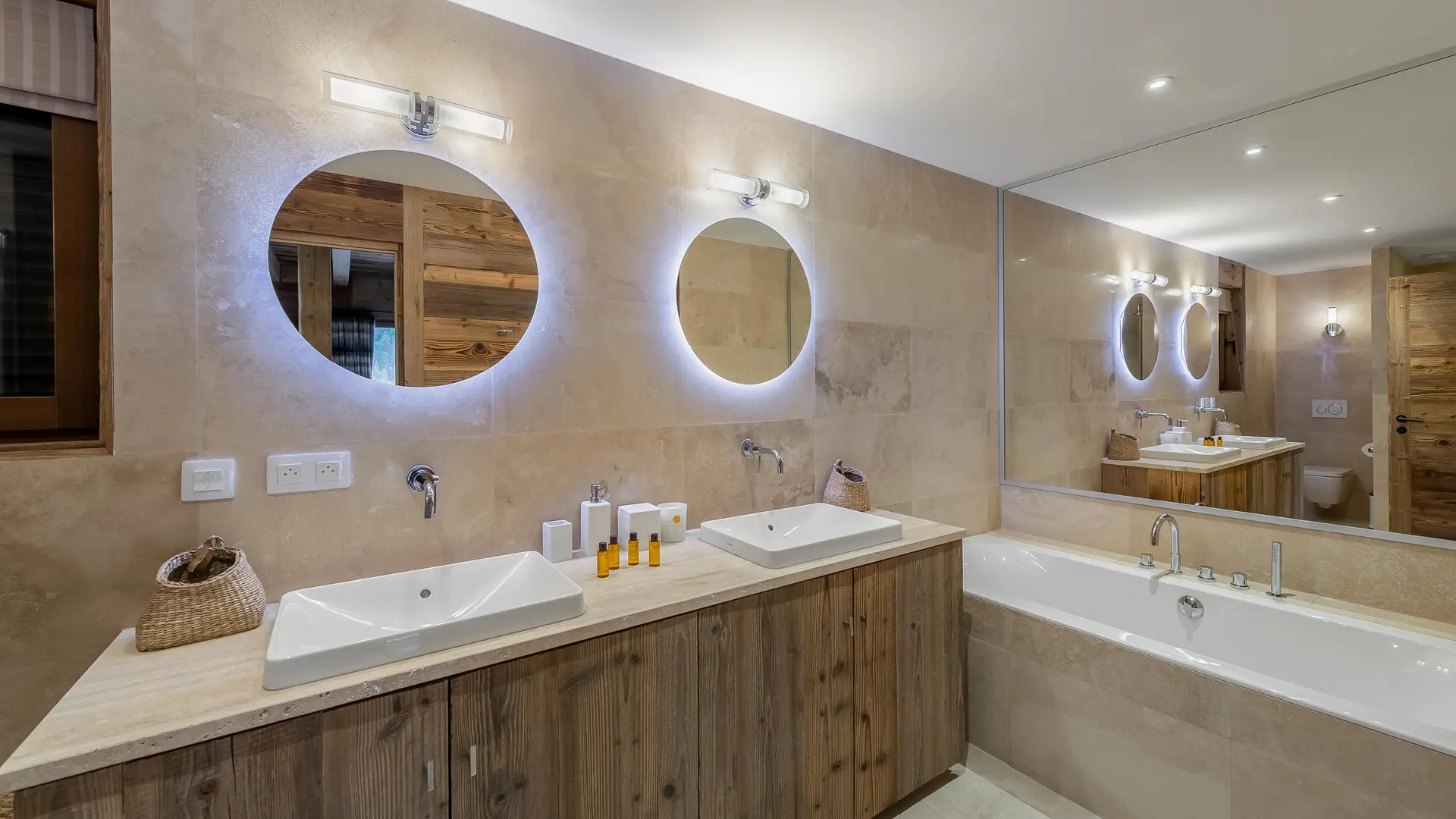 Double vasque avec meuble en bois, miroirs ronds, grande baignoire
