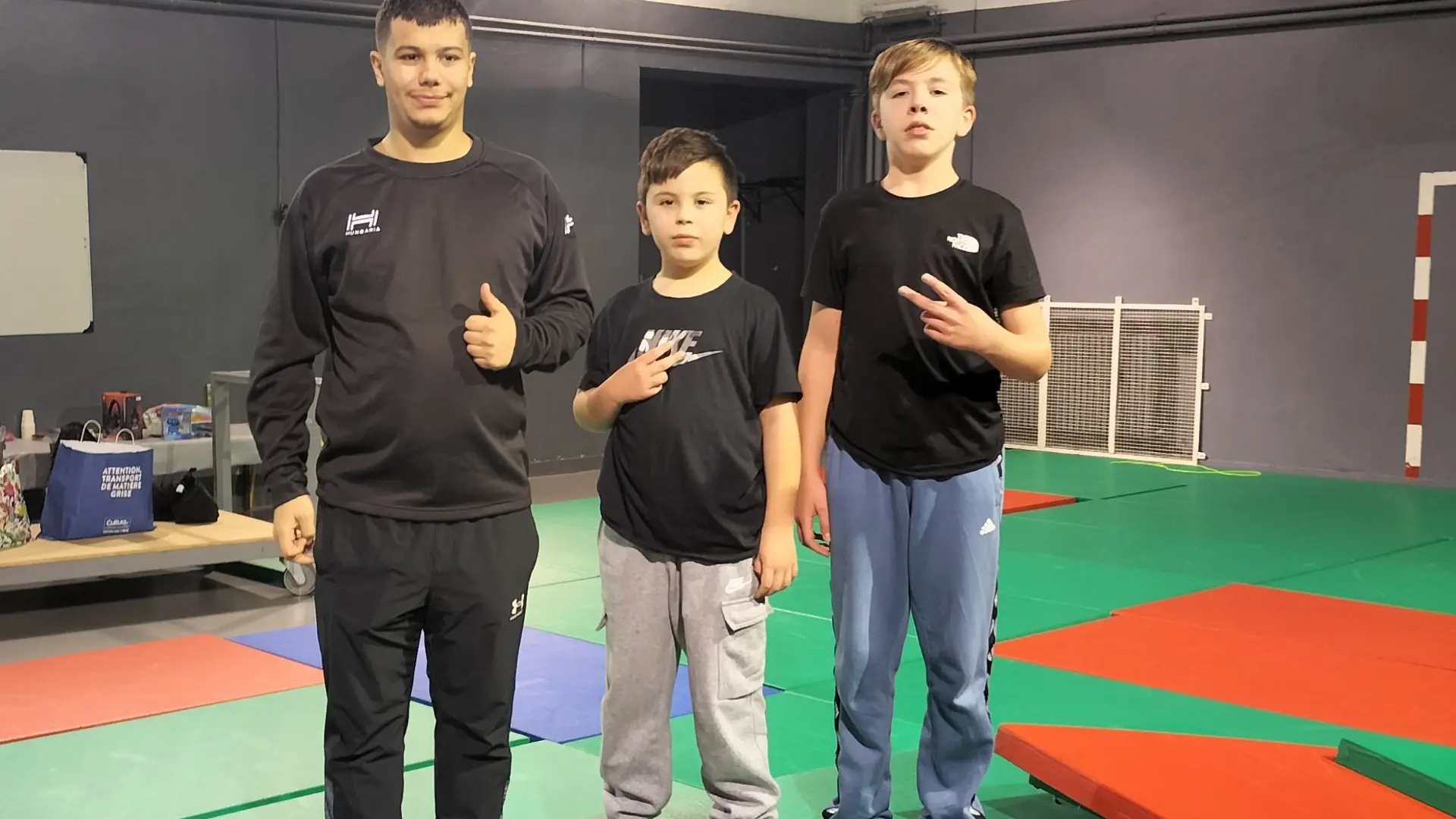 3 enfants qui posent sur des matelas d'entrainement