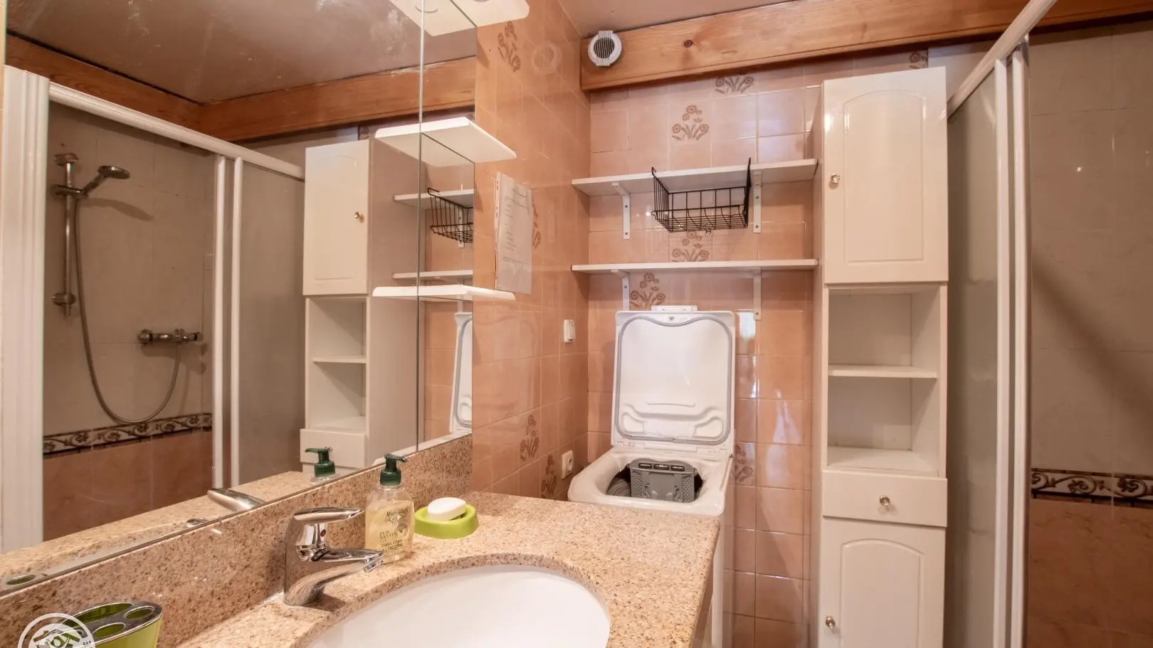 Douche et lave-linge dans la salle d'eau.