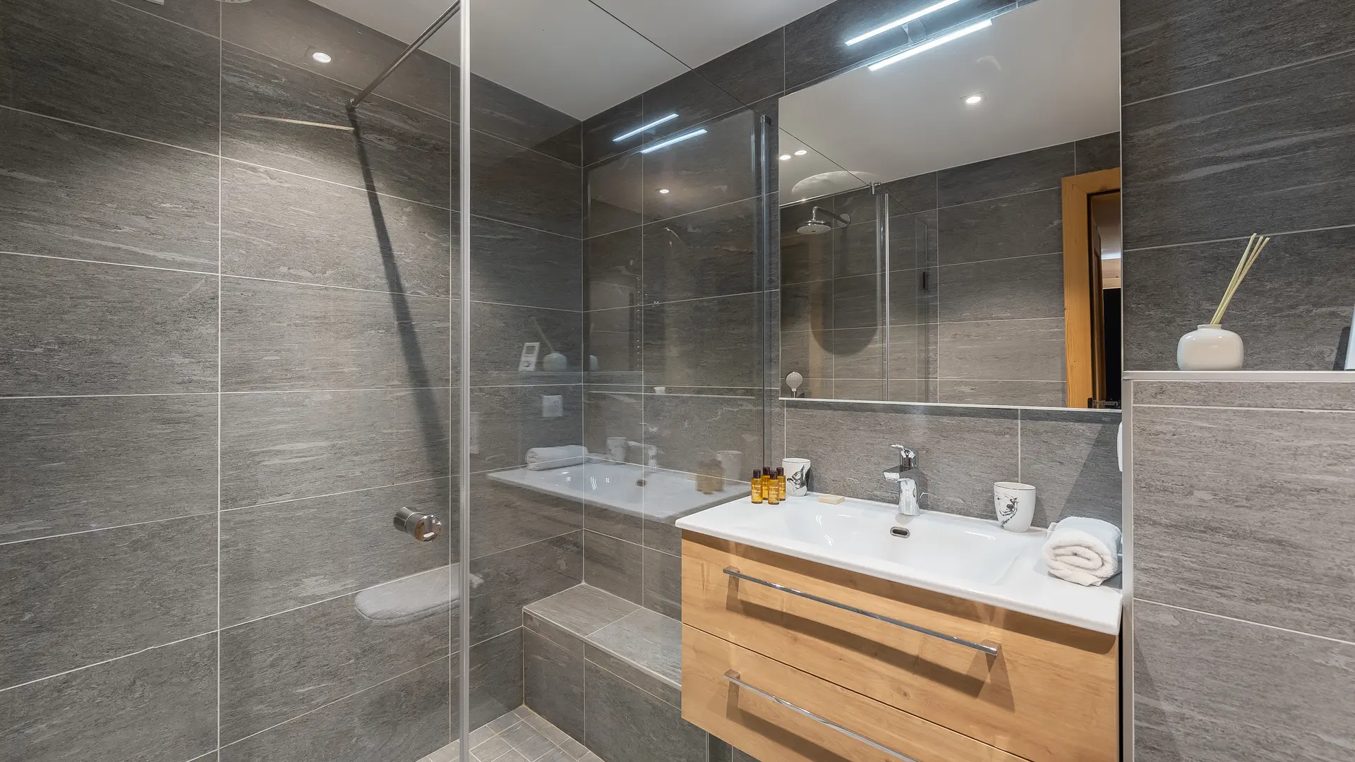 Salle de bains avec douche à l'italienne, grande vasque avec son meuble et grand miroir