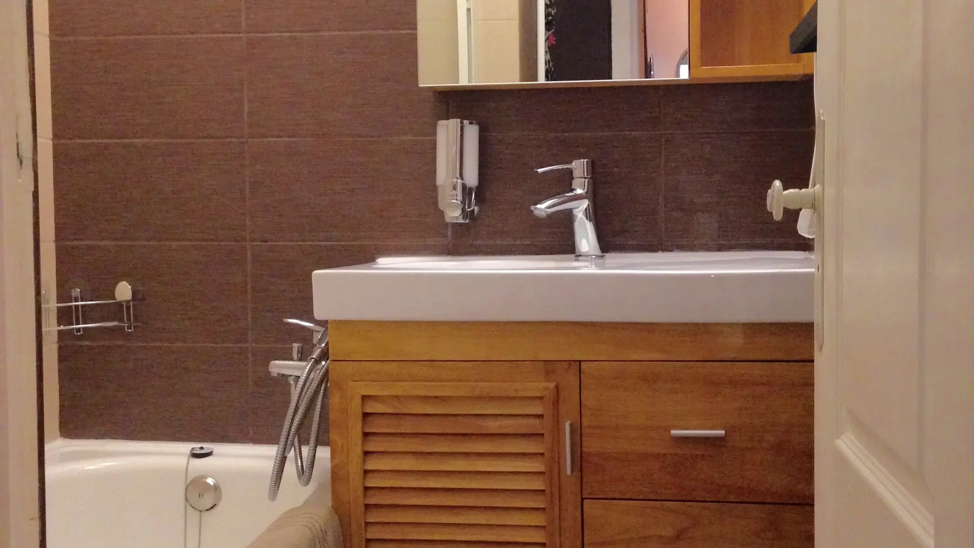 Salle de bain avec baignoire ou douche, sèche cheveux mural