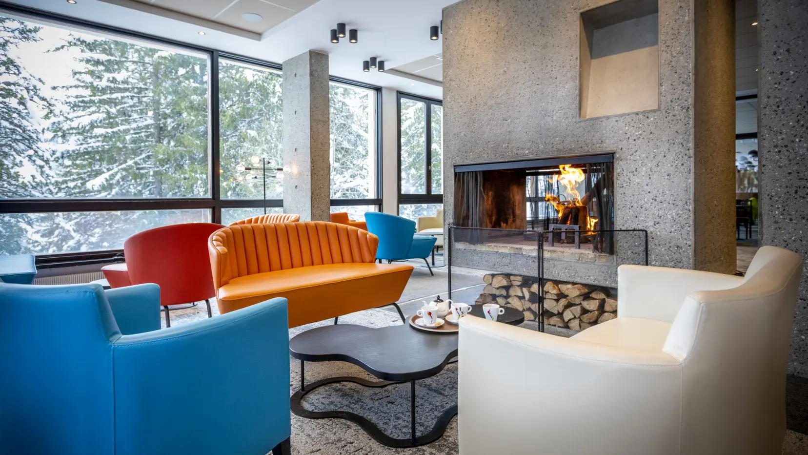 La salle du bar avec fauteuils confortables et cheminée