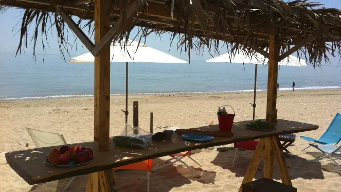 Table ombragée les pieds dans le sable