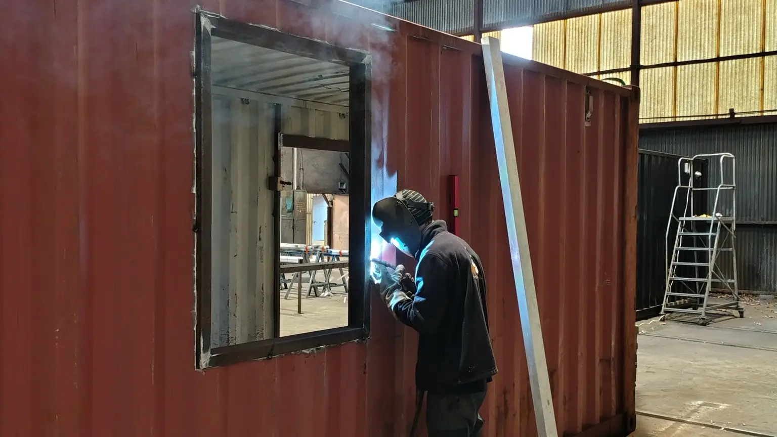 Un employé travaillant le métal du container