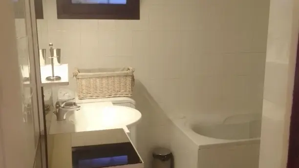 Salle de bains fonctionnelle avec une baignoire, une douche et un lave-linge.