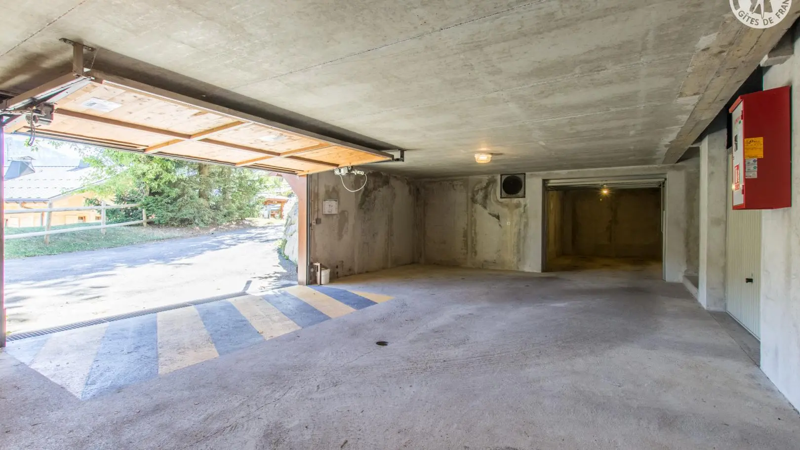 Garage privatif (porte ouverte au fond)