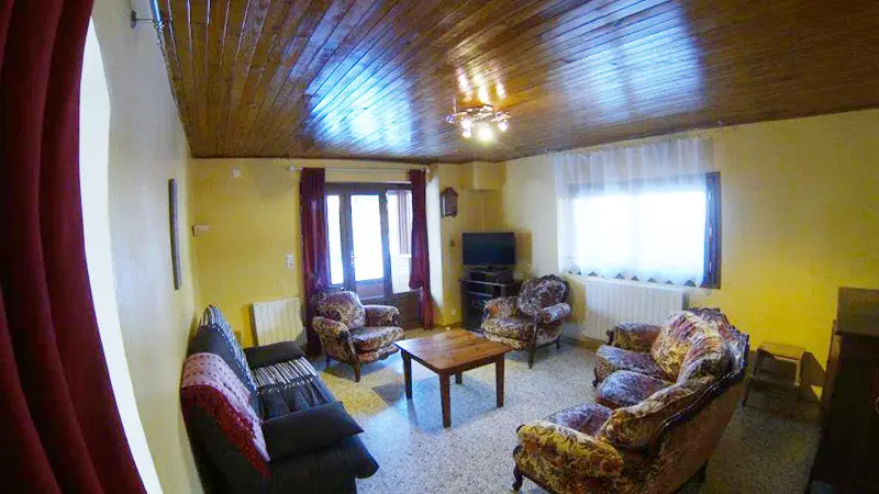 Bright living room with sofas, armchairs, coffee table, carpeted floor, window and French doors