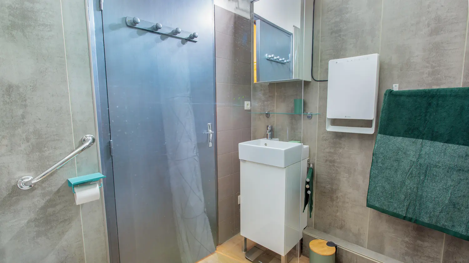 Une petite salle de bain moderne avec une douche en verre, un meuble blanc et des touches de vert.