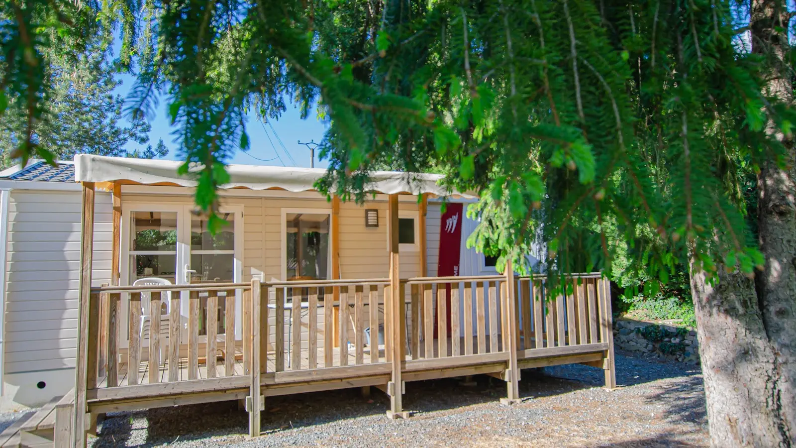 Le lodge est  situé dans un environnement arboré, avec une terrasse en bois.