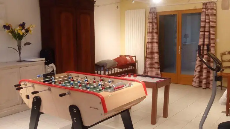 Une grande pièce comprenant un espace jeux pour petits et grands.