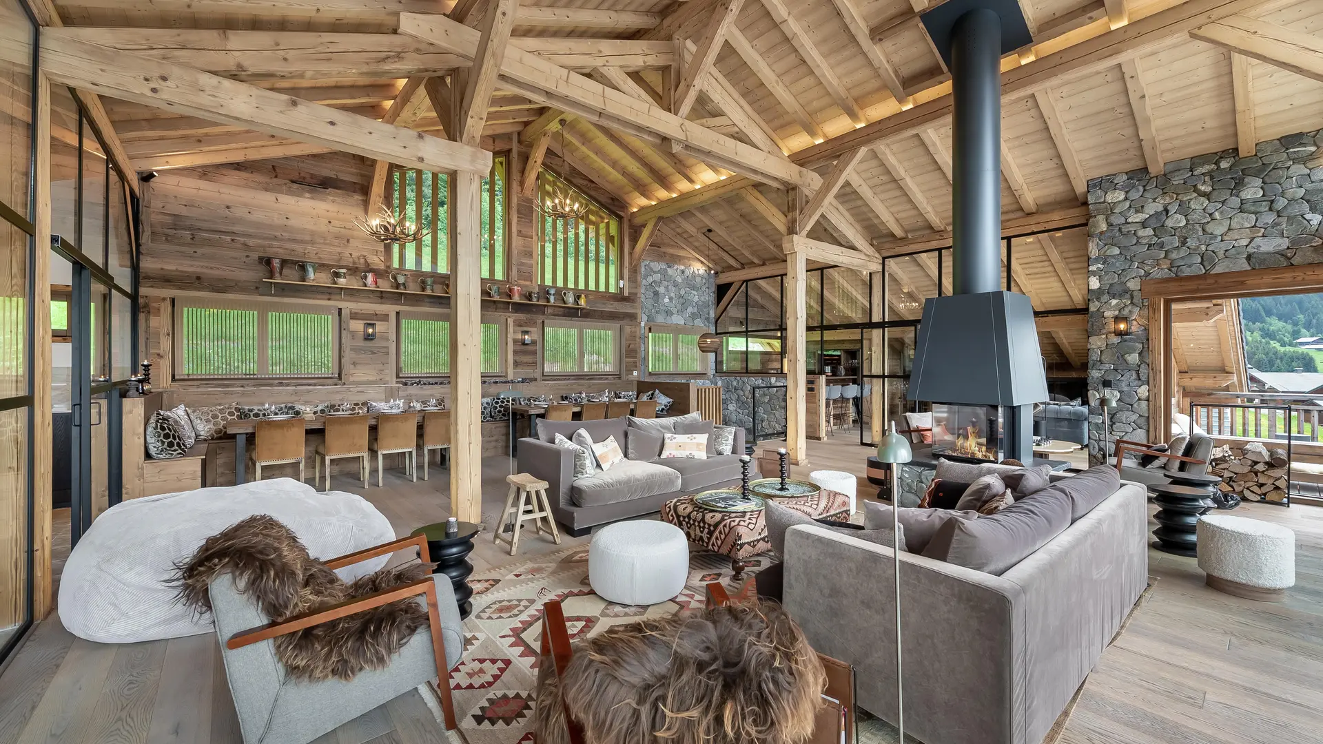 Salon avec ses fauteuils et canapés, cheminée, salle à manger en arrière plan