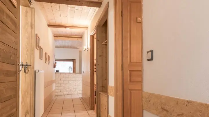 Entrée du gîte desservant les 2 chambres, la salle d'eau et le Wc indépendant . Couloir conduisant vers un grand espace séjour cuisine salon avec accès sur une terrasse couverte.