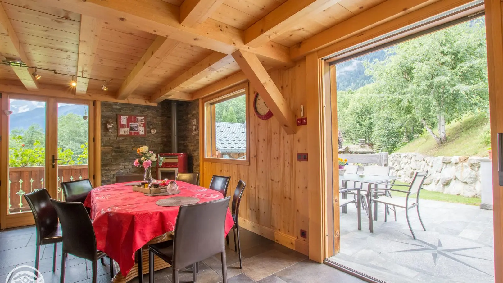 coin repas qui donne sur la terrasse  en pierre avec table et chaises
