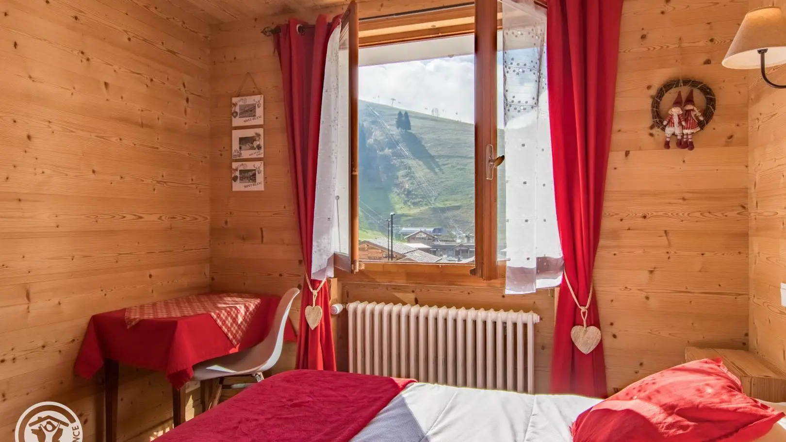 Vue depuis la chambre sur les pistes de ski et les prés verts l'été