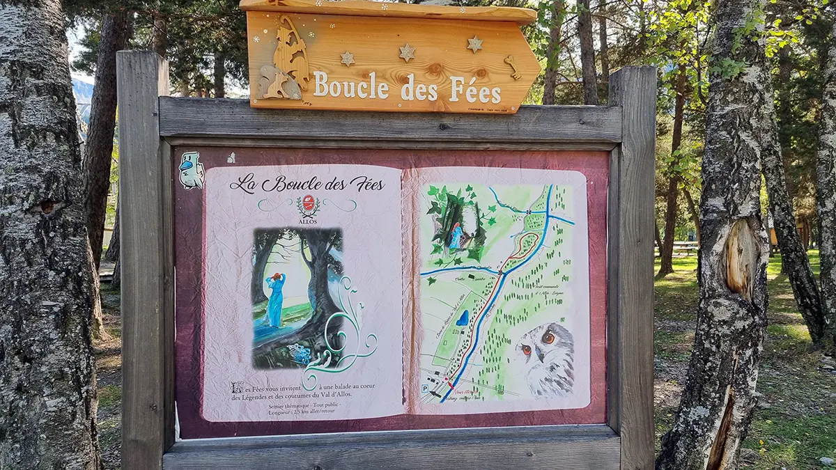 Panneau d'information au départ de la randonnée dans une forêt, inscription La Boucle des Fées