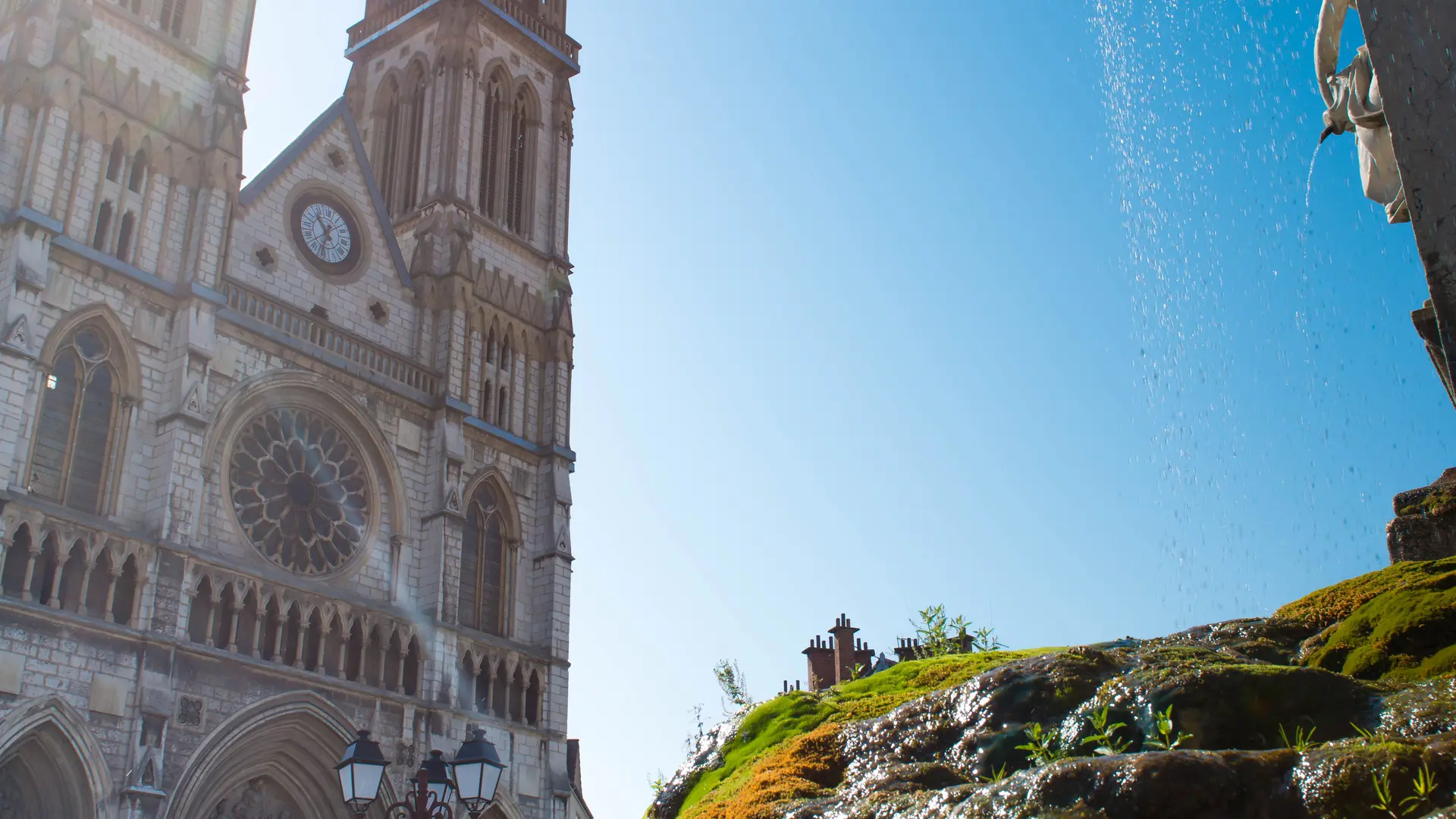 Eglise Saint-Bruno Voiron vue depuis la fontaine avec rayon de soleil en arriere plan