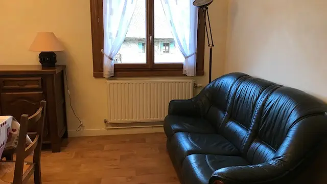 canapé en cuir noir dans le séjour à côté de la fenêtre