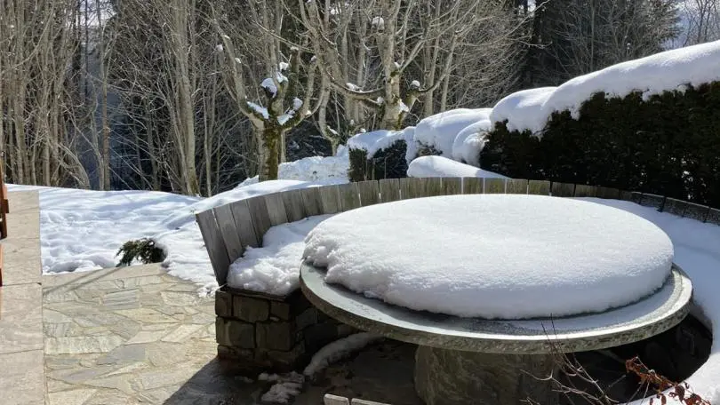 Terrasse avec table en pierre, recouverte de neige