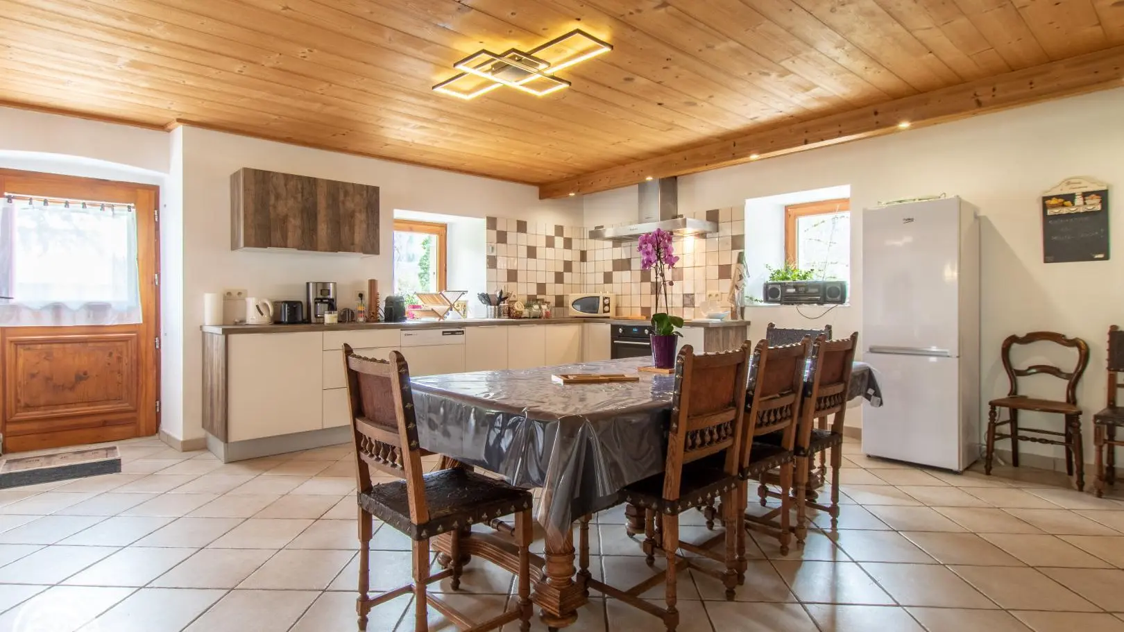 vue d'ensemble sur la cuisine, avec une grande table avec chaises et un banc