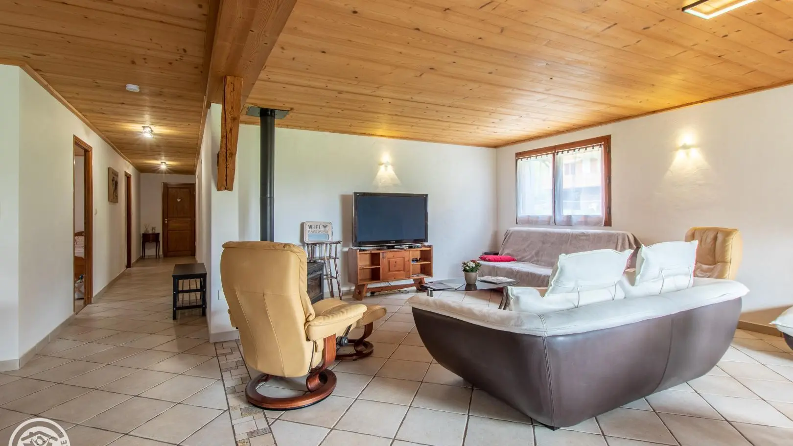 salon, avec un canapé 3 places, 2 fauteuils avec repose-pied, un canapé clique-clac 3 places, une télé