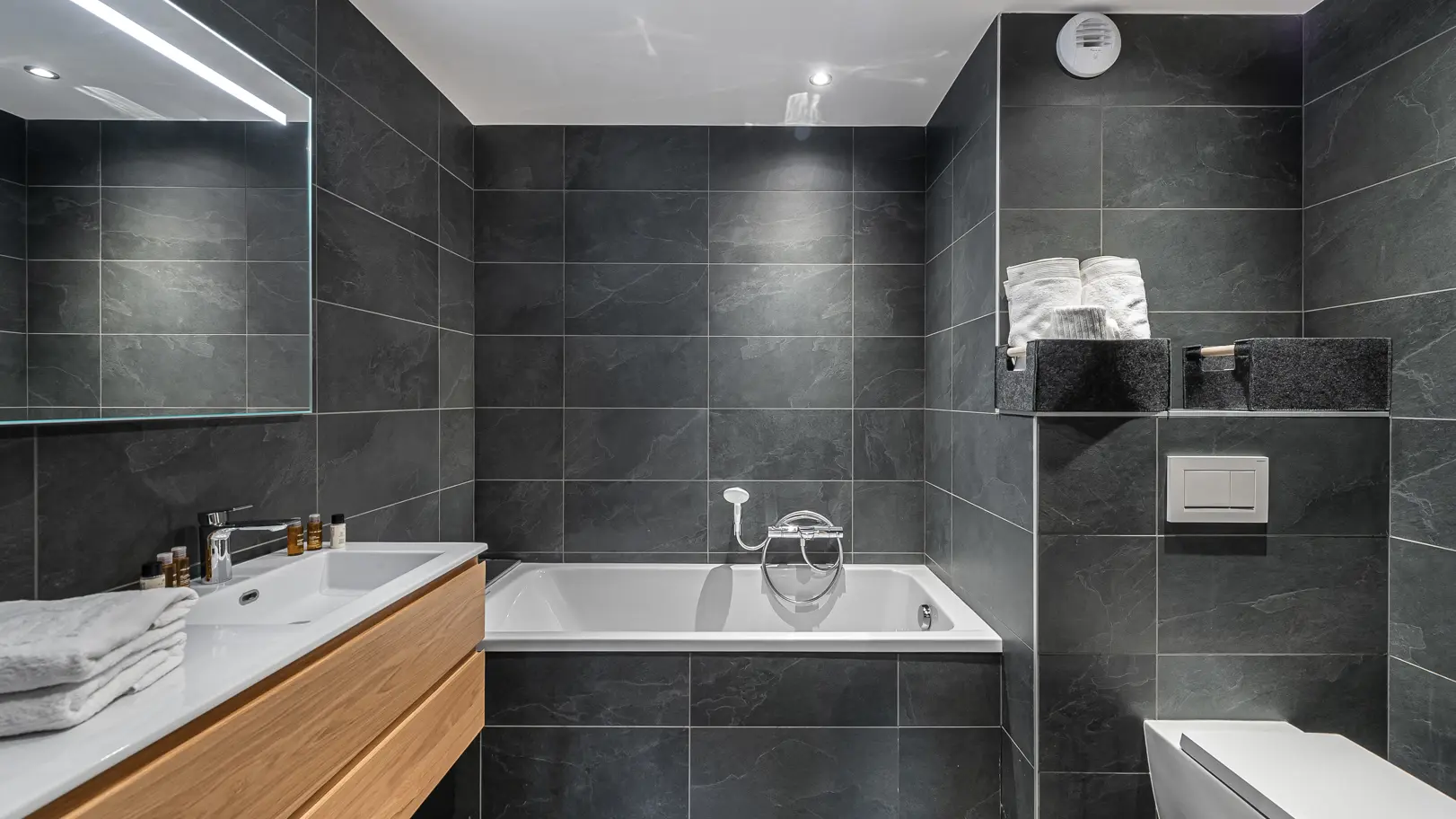 Salle de bains avec baignoire, grande vasque avec son meuble et grand miroir, toilettes