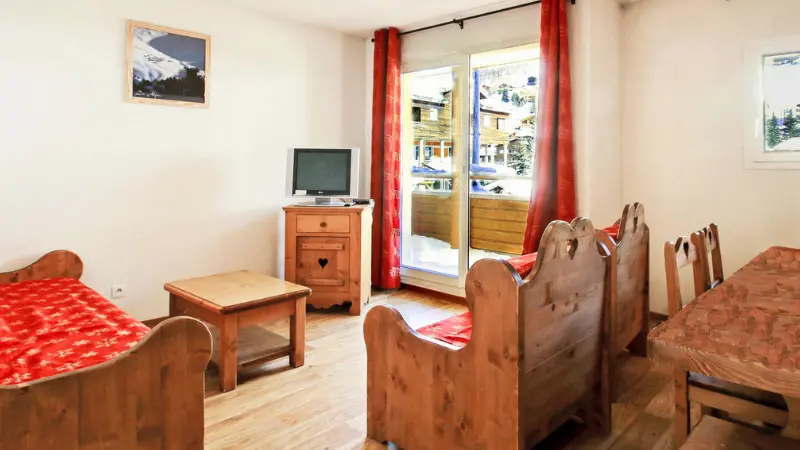Bright apartment living room with sofa, armchair, coffee table, French doors opening onto a terrace