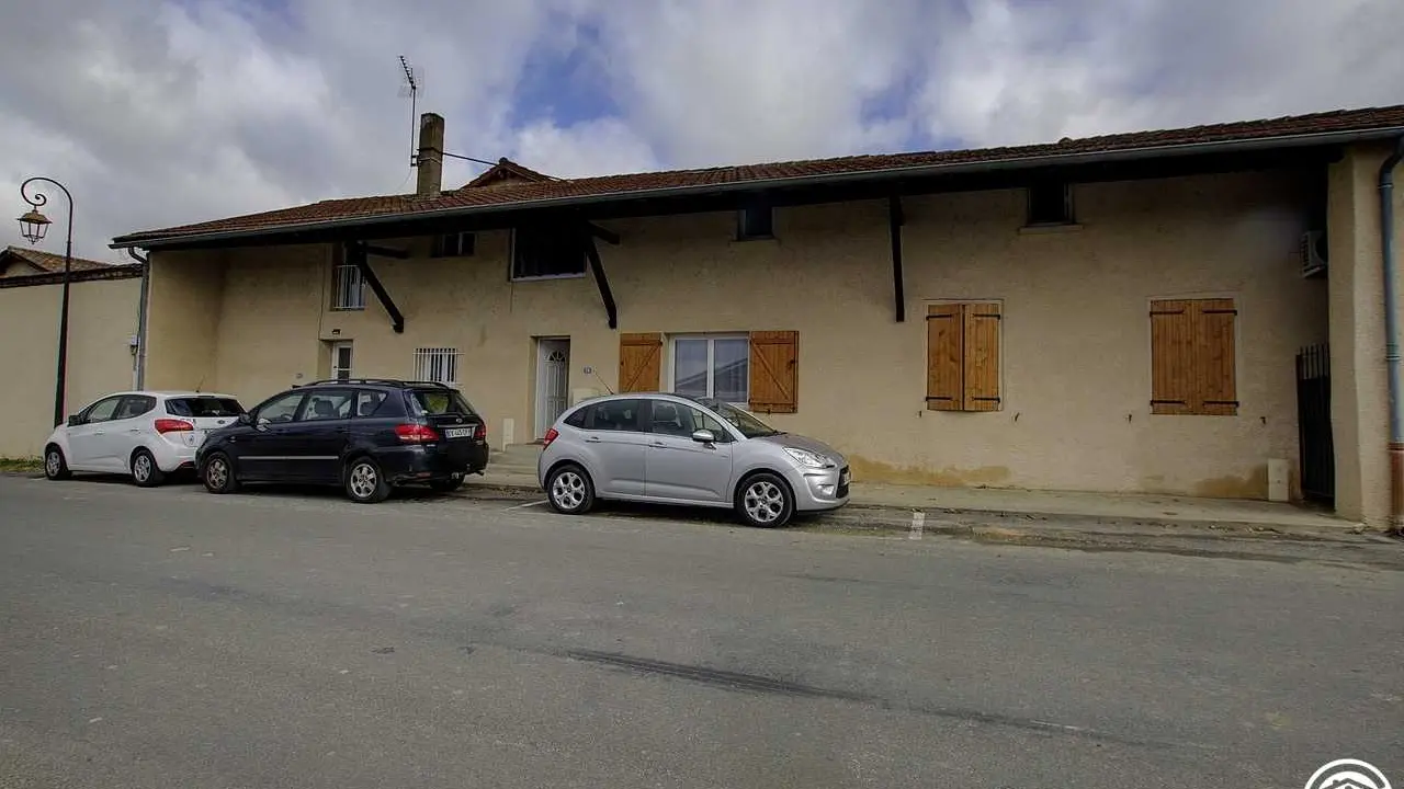 La vue sur la l'entrée principale du gîte(qui se situe au milieu avec porte et volet ouvert.