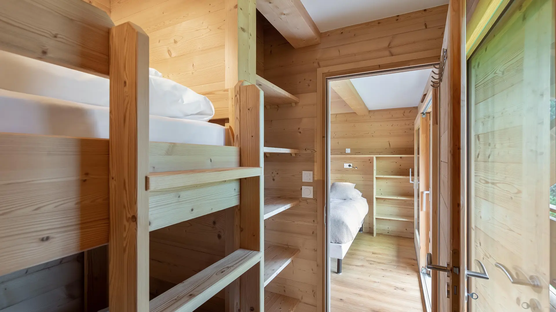 Chambre familiale avec lits superposés au premier plan et chambre des parents en arrière plan