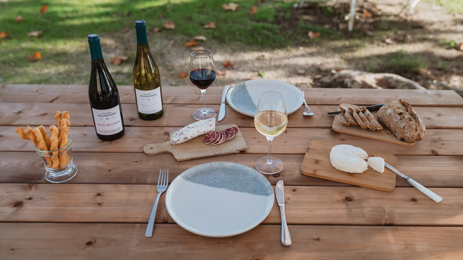 Table pour repas avec assiette et verres pour un repas au milieu des vignes.