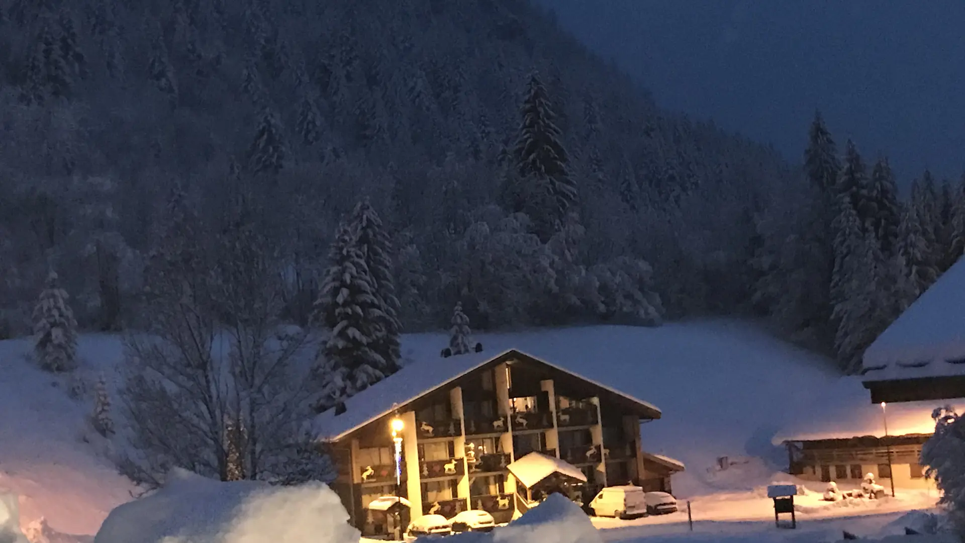 Vue de l'hôtel en hiver sous la neige la nuit