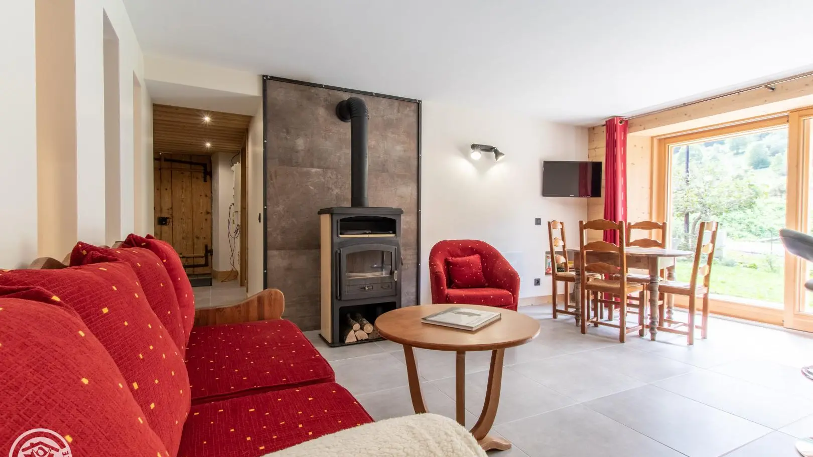 Séjour avec cuisine intégrée, table, poêle à bois