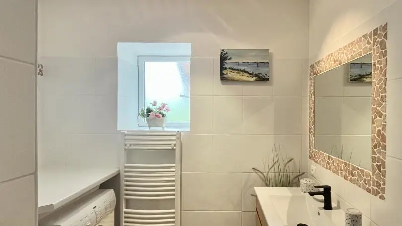 Salle de bain avec lave linge et fenêtre