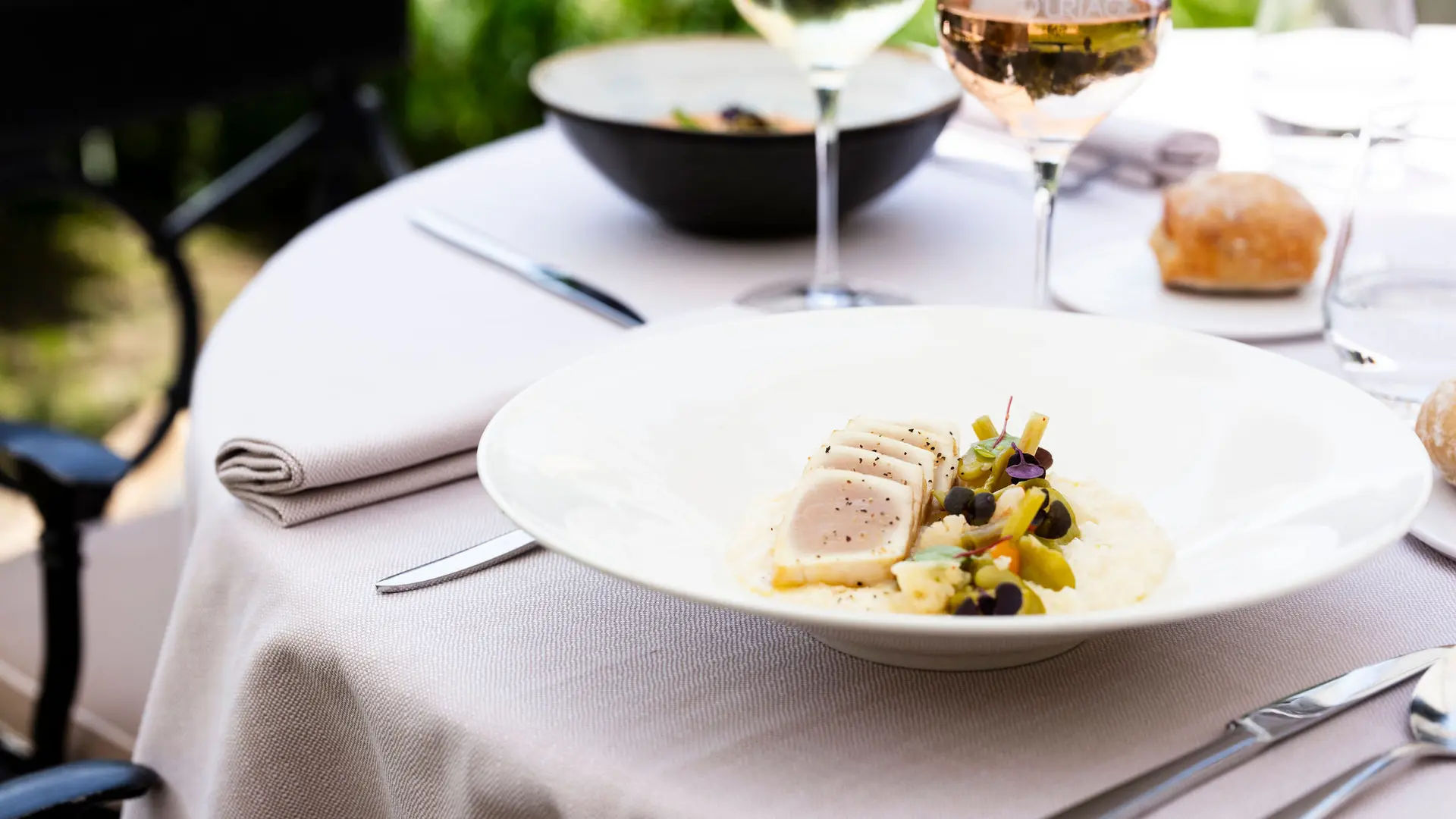 Une vue d'un plat de poisson, accompagné de légumes et d'une purée, dressé sur une table dressée pour un repas.