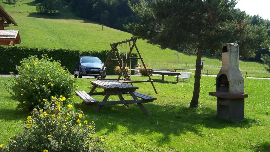 Jardin avec table et barbecue.