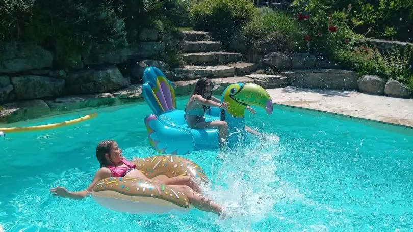 Piscine partagée avec gite en arrière plan