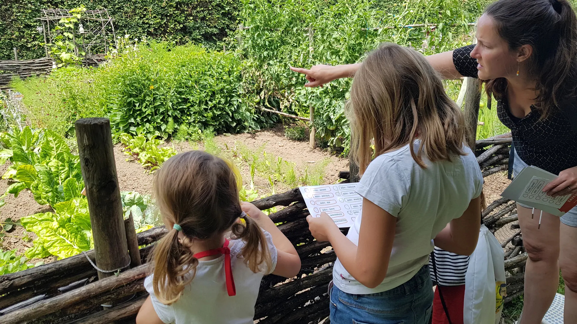 Enfants avec le Sac Défi Saveurs découvrant le potager