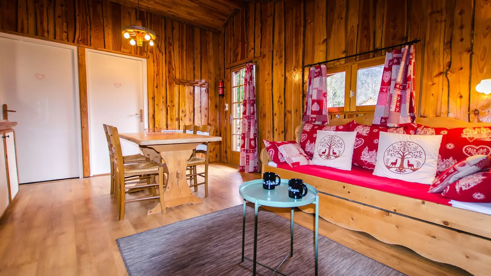 Le chalet présente un intérieur en bois chaleureux avec un salon meublé d'un canapé et d'une table basse.