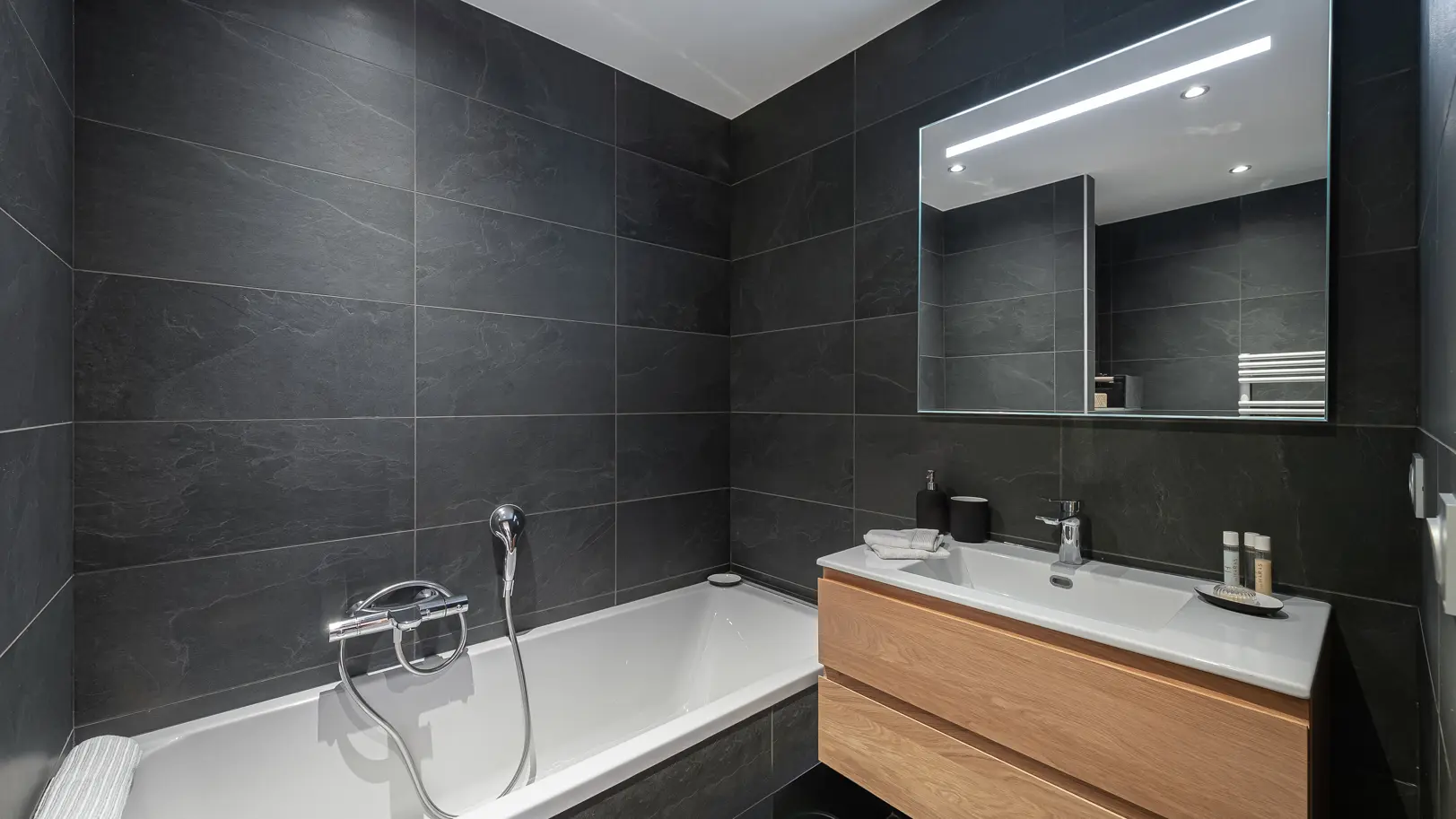 Salle de bains avec grande vasque, son meuble et miroir, baignoire