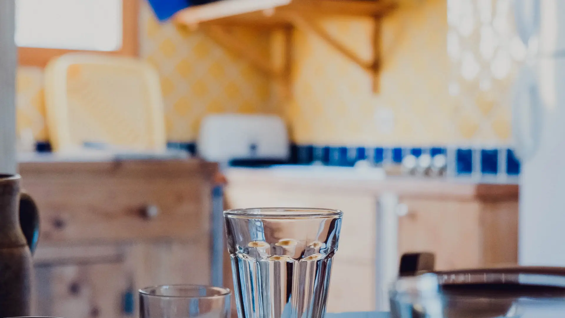 Gros plan sur une table dressée avec une cuisine floutée en arrière plan.