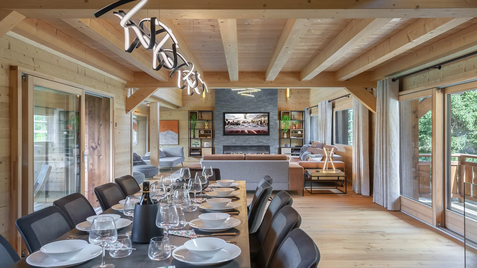 Salle à manger avec en arrière plan l'espace salon et sa cheminée