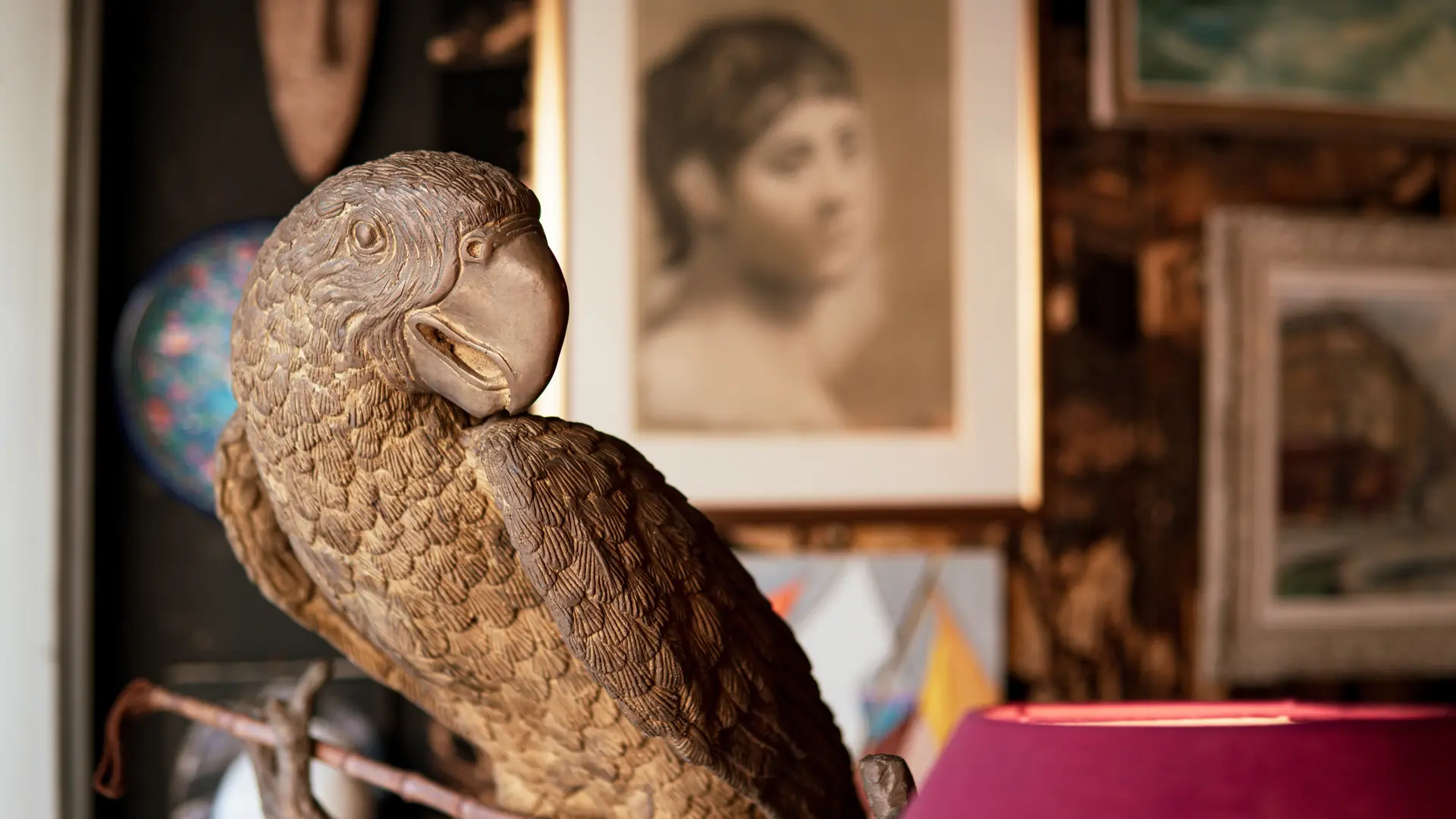 Une sculpture détaillée de perroquet trône fièrement au milieu d’un décor artistique et feutré.