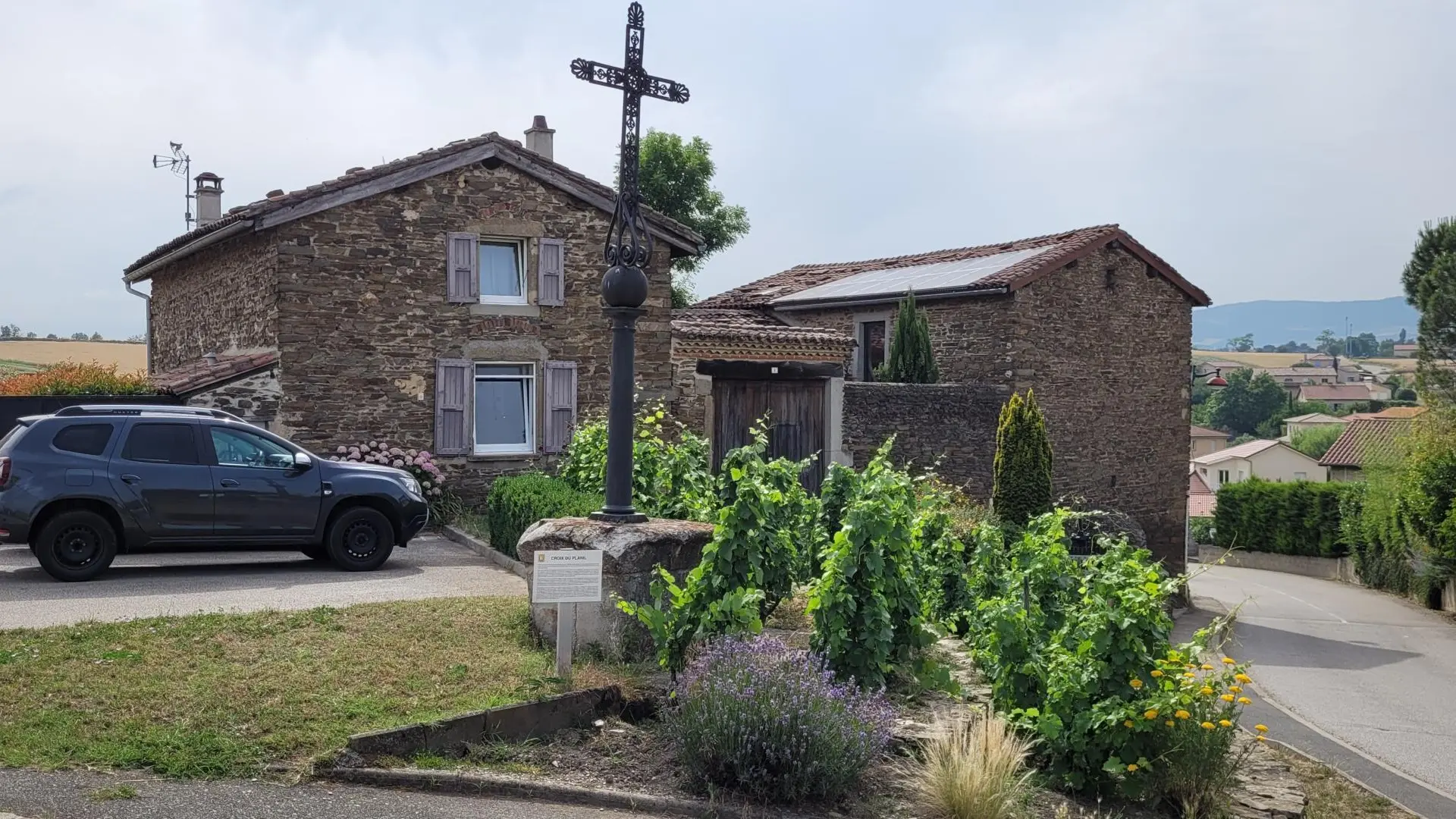 Vue de la maison côté village avec parking.