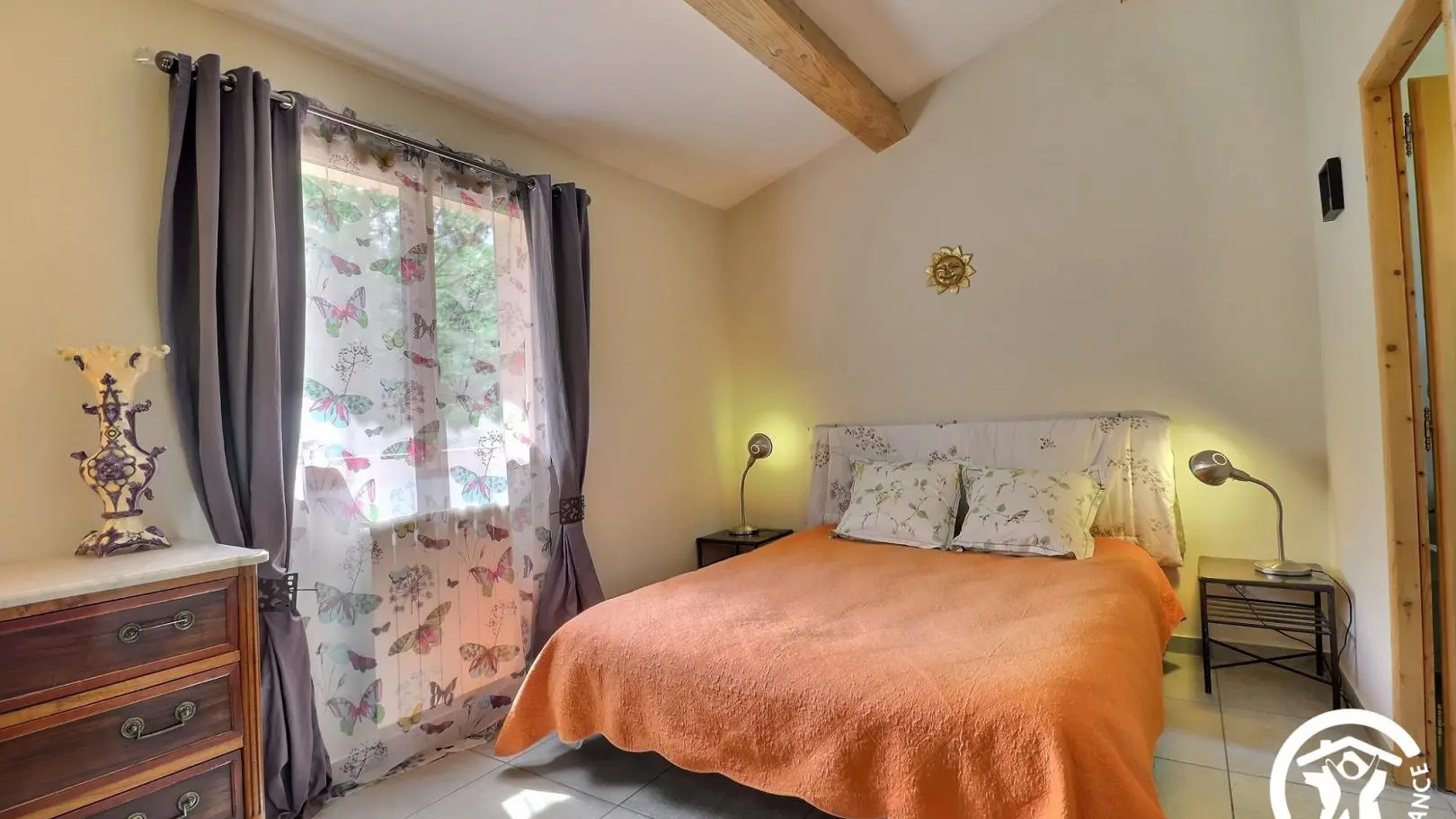 La chambre aux voutes apparentes avec vue sur le jardin .