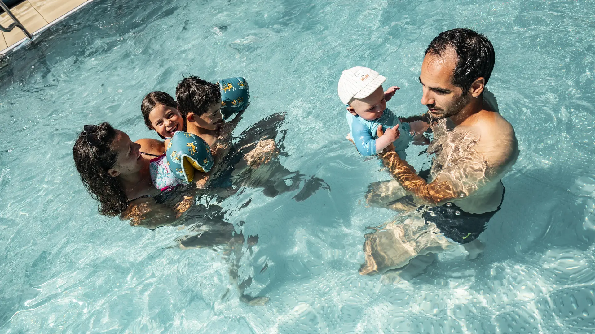 En famille dans le bassin extérieur en été du centre aquatique