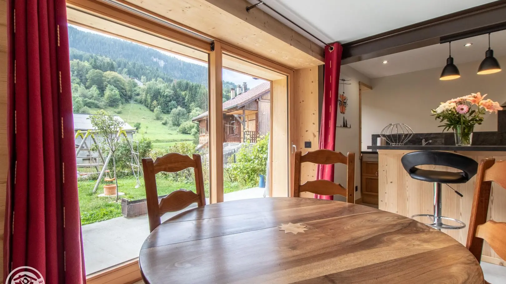 Séjour avec cuisine intégrée, table, poêle à bois