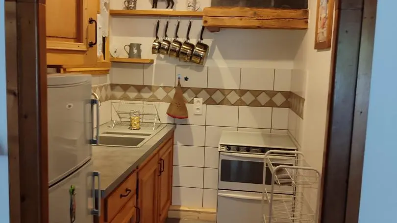 passage du salon au coin cuisine.il y a le refrigerateur, congelateur, le trio (3 gaz + 1 plaque electrique , le four et le lave vaisselle